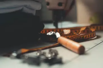 Herramientas y muestras de tejido sobre la mesa de un taller textil.