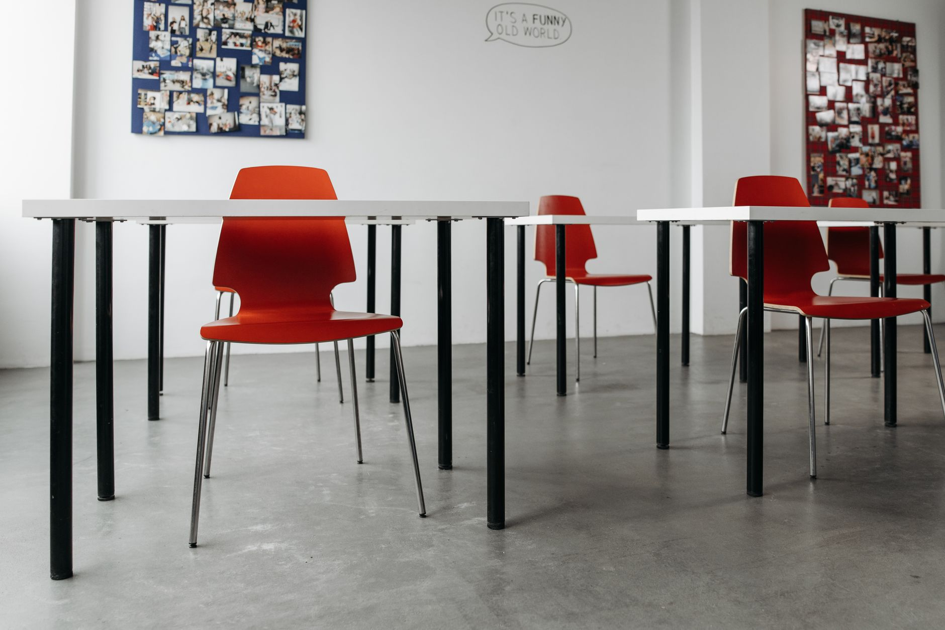 Escena conceptual de formación práctica en inteligencia artificial: una persona adulta no identificable trabaja en un aula-taller sobria, junto a un portátil sin marca y un pequeño sensor, con el entorno urbano y rural de Badajoz al fondo.